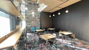 a dining room with tables and chairs and a mural at Noir Hotel in Szeged