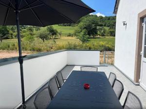 a black table with chairs and an umbrella on a patio at Feriendomizil im Saarschleifenland in Mettlach