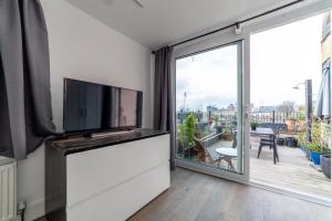 a living room with a tv and a large window at The Nine Elms Collection in London