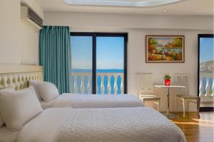 萨兰达Hotel Iliria的一间带两张床的卧室，可欣赏海景