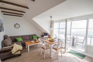 a living room with a couch and a table at Haus Halligenblick Amrum in Wittdün