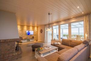 a living room with a couch and a fireplace at Haus Halligenblick Amrum in Wittdün