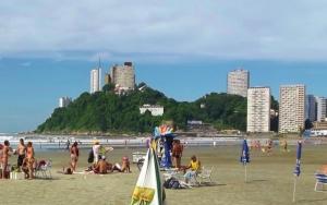 eine Gruppe von Menschen am Strand in der Unterkunft Apartamento na Praia de Itararé in São Vicente