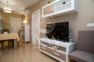 ein Wohnzimmer mit einem TV und einem Esszimmer in der Unterkunft Casa Esona Ivan Luxury Homes 9ªPlta Norte 1ªLinea in Oropesa del Mar