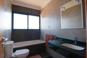 een badkamer met toilet, wastafel en bad bij Casa Nici in Calheta +22 foto's
