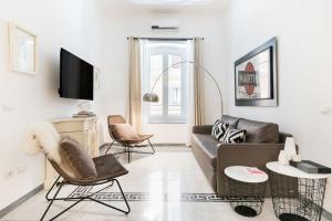 ein Wohnzimmer mit einem Sofa und Stühlen in der Unterkunft Modern Comfort, Poetic Charm in Rom