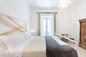 ein weißes Schlafzimmer mit einem großen Bett und einem Fenster in der Unterkunft Modern Comfort, Poetic Charm in Rom