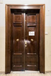 eine große Holztür in einem Gebäude in der Unterkunft Modern Comfort, Poetic Charm in Rom