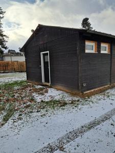 ein kleines Gebäude mit einer Tür im Schnee in der Unterkunft Ferienhaus am Edersee-scheid in Waldeck