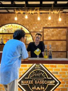 twee mannen aan een bar met een Benson teken bij Japanese house in Ban Non Sombun