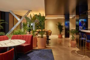 a lobby with red chairs and potted plants at Crowne Plaza Madrid - Centre Retiro, an IHG Hotel in Madrid