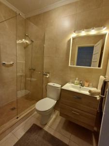uma casa de banho com um WC, um chuveiro e um lavatório. em Happy Heart Los Molinos em Costa Teguise