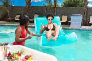 a woman in a bikini sitting on a raft in a swimming pool at Mohlaletse Guest House in Ga-Matsi