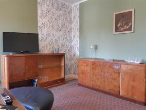 a room with a large wooden dresser with a flat screen tv at NEU! Moderne Ferienwohnung Zwickau in Zwickau