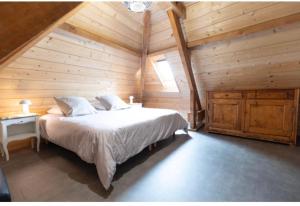 a bedroom with a bed in a log cabin at Villa de Lurp panorama spa 12 pers in Saint-Pastous