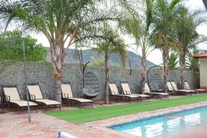 a group of chairs sitting next to a swimming pool at Mohlaletse Guest House in Ga-Matsi