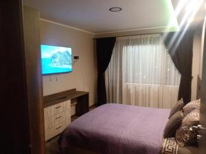 Habitación de hotel con cama y TV de pantalla plana. en Кръчмъ При Байката апарт, en Teteven