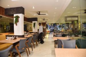 een man in een restaurant met tafels en stoelen bij Hotel Sai Krishna in Shirdi