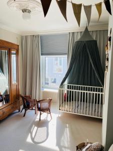 um quarto para bebés com um berço e um dossel em Familiehuis aan zee met ruim dakterras em Zandvoort