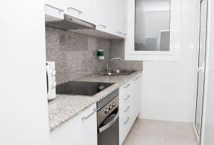 cocina blanca con lavabo y espejo en Sant Jordi Apartments Sagrada Familia en Barcelona