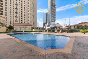 a swimming pool in the middle of a city with tall buildings at Keysplease Modern Studio Near Beach, Murjan JBR 617 in Dubai