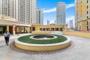 a woman walking through a mall with a large fountain at Keysplease Modern Studio Near Beach, Murjan JBR 617 in Dubai