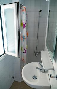 a bathroom with a sink and a shower curtain at HOSTAL CACHE in Baza