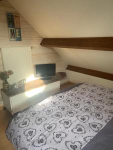 a bedroom with a bed and a flat screen tv at Agréable chambres d’hôte in Parence