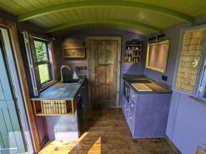 a kitchen with purple counters and a sink at Blue Sky Huts in Chediston