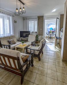 a living room with couches and chairs and a tv at Kathy Panzió in Balatongyörök