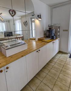 a kitchen with white cabinets and a wooden counter top at Kathy Panzió in Balatongyörök