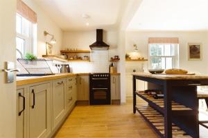 a kitchen with a island in the middle of it at Gatehouse North in Worstead