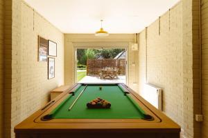 a pool table in the middle of a room at Gatehouse North in Worstead