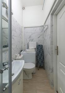 a bathroom with a white toilet and a sink at Old town apartment with free parking by Polo Apartments in Kaunas