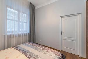 a bedroom with a bed with a door and a window at Old town apartment with free parking by Polo Apartments in Kaunas