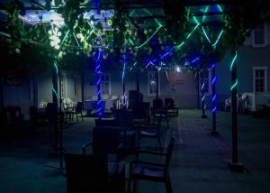 a patio with blue and green lights and chairs at BOSS HOTELS & SUITES in Lagos