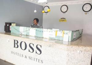 una donna seduta a una scrivania con un portatile di BOSS HOTELS & SUITES a Lagos