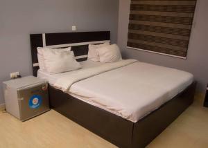 a bedroom with a large bed with white sheets at BOSS HOTELS & SUITES in Lagos