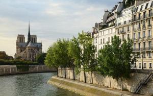 a river with buildings and trees next to a building at Appartement de standing sur l'île Saint-Louis by Weekome in Paris