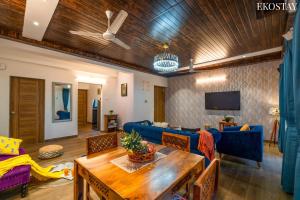 a living room with a blue couch and a table at EKOSTAY - Bliss Apartment in Candolim