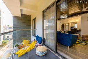 a living room with a blue couch on a balcony at EKOSTAY - Bliss Apartment in Candolim
