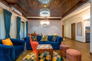 a living room with blue couches and chairs at EKOSTAY - Bliss Apartment in Candolim