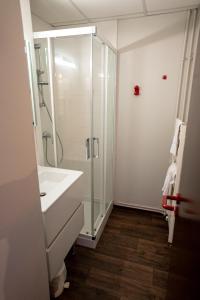 a white bathroom with a shower and a sink at Azureva Bussang in Bussang