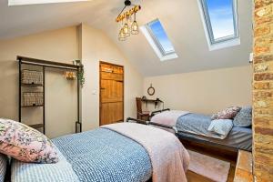 two beds in a attic room with skylights at Finest Retreats - The Old Smithy in Belchford