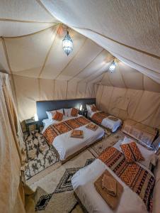 um quarto com duas camas numa tenda em Merzouga Luxury Tent em Merzouga