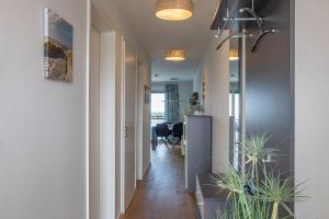 a hallway with white walls and potted plants at Fewo Reeder's Nest by Seeblick Ferien ORO, 2-Zi-Hafenwohnung, Fahrstuhl in Olpenitz