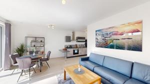 a living room with a blue couch and a table at SweetHome - Poing Apartments in Poing