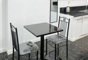 ボラカイにあるStay Inn Station 2 Boracay by RedDoorzの黒いテーブルと椅子2脚付きのキッチン