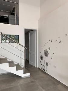 a room with a staircase with dandelions and butterflies on the wall at Urban charme loft in Dorgali