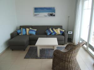 ein Wohnzimmer mit einem Sofa und einem Tisch in der Unterkunft Ferienhaus Strand Hus by Seeblick Ferien ORO, Bestlage am Strand,Sauna,Kamin in Olpenitz
